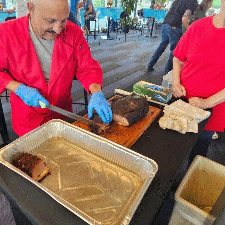 Jim Carroll slicing brisket for guests at an event