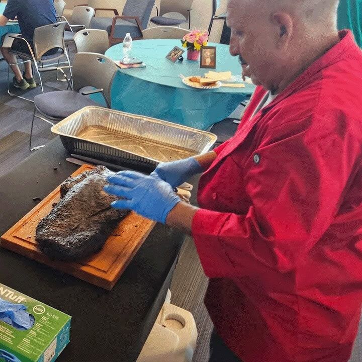 Jim unwrapping a brisket at the serving table